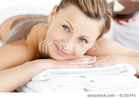 Portrait of a radiant woman lying on a massage table with mud on Portrait of a radiant woman lying on a massage table with mud on 6230743