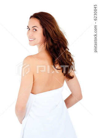 Radiant caucasian woman with a towel on her body smiling at the 6230845