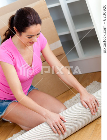 Happy woman rolling a carpet out Happy woman rolling a carpet out 6230920