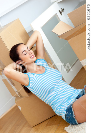Relaxing woman sitting on the floor after unpacking boxes Relaxing woman sitting on the floor after unpacking boxes 6231676