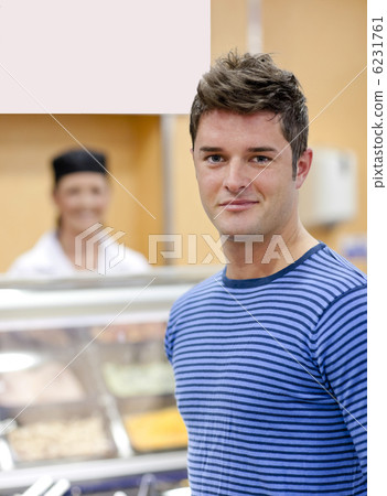 Portrait of a cheerful man choosing his lunch in the cafeteria Portrait of a cheerful man choosing his lunch in the cafeteria 6231761