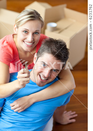 portrait of a joyful couple in their new house with woman showin portrait of a joyful couple in their new house with woman showin 6231762