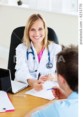 joyful female doctor giving a prescription to her patient in the joyful female doctor giving a prescription to her patient in the 6231770