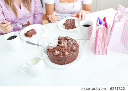 Close-up of caucasian female friends eating a chocolate cake in 6231822
