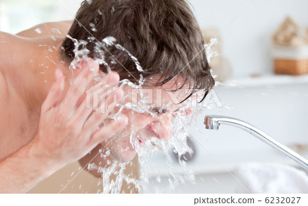 Bright caucasian man spraying water on his face after shaving in Bright caucasian man spraying water on his face after shaving in 6232027