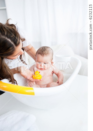 Beautiful mother giving the bath to her baby Beautiful mother giving the bath to her baby 6232115