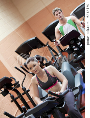 Serious young couple doing exercises using equipments in a sport 6232170
