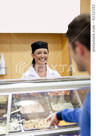 Handsome student showing his choise to the cook in the cafeteria 6232182