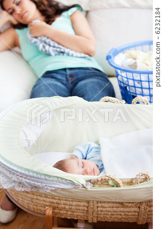 Cute baby sleeping in his cradle with his mother lying on the co Cute baby sleeping in his cradle with his mother lying on the co 6232184