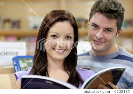 Portrait of a cute couple reading a book in a shop 6232185