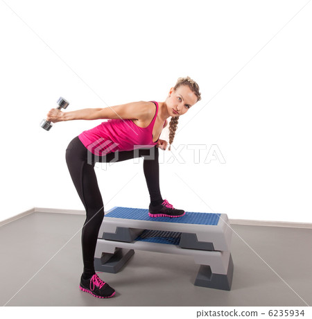 Athletic young woman training with dumbbell 6235934