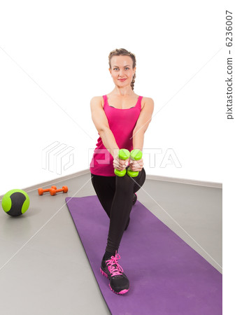 Athletic young woman training with dumbbells 6236007
