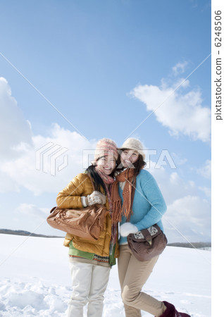 Two women smiling at the snowy field 6248506