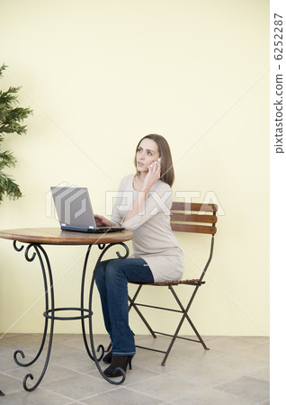 操作膝上型計算機和智能手機的白夫人在咖啡館 6252287