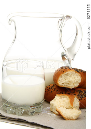 Bagel with poppy seeds a pitcher of milk. 6275555