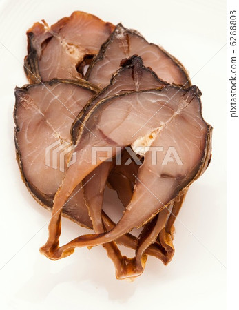 sliced smoked fish on plate on white 6288803