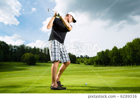 Young golf player on course doing golf swing 6289316