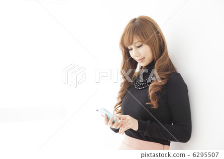 A black knit woman using a smartphone A black knit woman using a smartphone 6295507