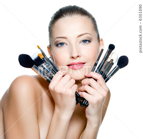 Beautiful young woman holding make-up brushes Beautiful young woman holding make-up brushes 6301890
