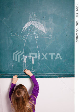 Young girl drawing on chalkboard 6316852