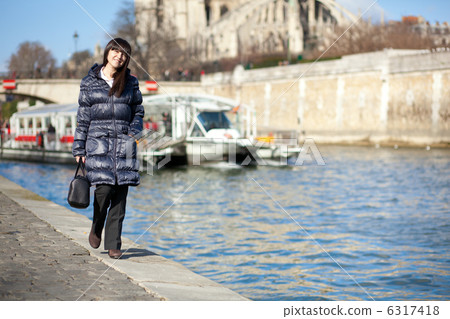 Beautiful brunette tourist walking at the emankment in Paris 6317418