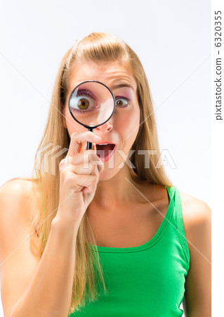 Woman looking through magnifying glass or loupe Woman looking through magnifying glass or loupe 6320355