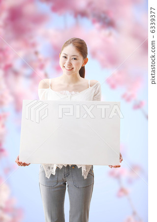 A woman with a white board and a cherry tree A woman with a white board and a cherry tree 6339377