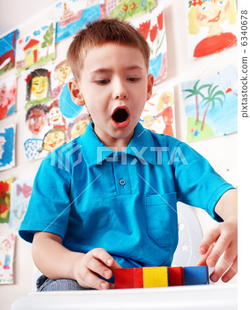 Child with wood block and construction set in play room. Child with wood block and construction set in play room. 6340678