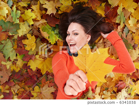 Young woman in autumn orange leaves. 6341038
