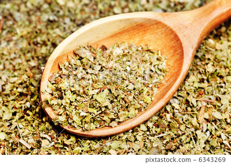 Dried marjoram spice and wood spoon as food background 6343269