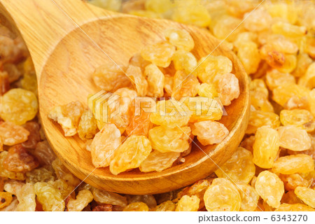 Golden raisins close- up and wooden spoon, food background 6343270