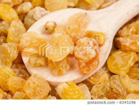 Golden raisins close- up and wooden spoon, food background 6343296