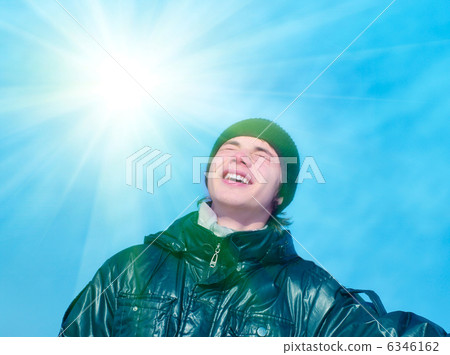 Smiling teenager on blue sky background Smiling teenager on blue sky background 6346162