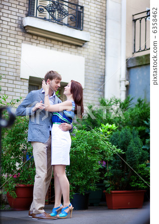 Happy positive couple hugging near their house on Montmartre in 6358462