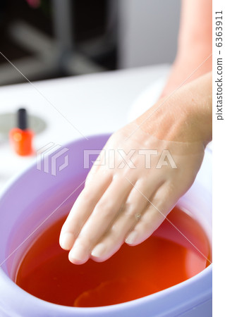 Woman in nail salon having paraffin bath 6363911