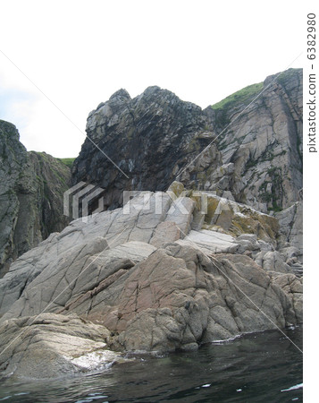 Rocks in the blue sea, illuminated by the sun. Background. 6382980