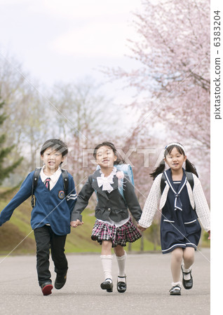 沿著櫻桃綠樹成蔭的大道走的小學學生 6383204