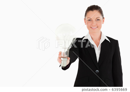Attractive woman in suit holding a light bulb while standing Attractive woman in suit holding a light bulb while standing 6395669