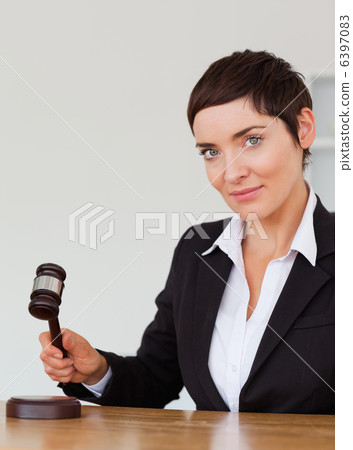 Portrait of a serious woman knocking a gavel Portrait of a serious woman knocking a gavel 6397083