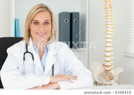 Smiling doctor with model spine next to her Smiling doctor with model spine next to her 6398419
