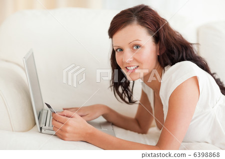 Gorgeous woman working on a laptop with a credit card Gorgeous woman working on a laptop with a credit card 6398868