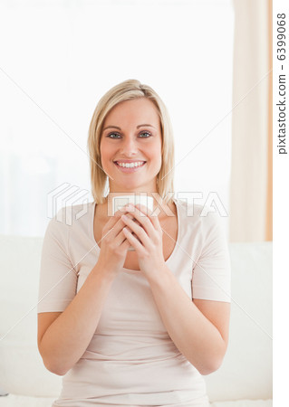 Portrait of a smiling woman holding a cup of tea 6399068