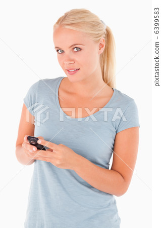 Woman dialing on a phone looking at the camrea Woman dialing on a phone looking at the camrea 6399583