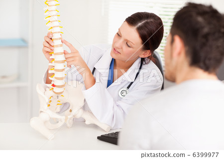 Female doctor pointing on bone in spine 6399977