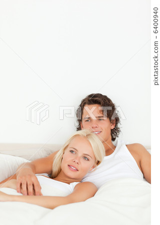 Portrait of a happy couple lying on a bed Portrait of a happy couple lying on a bed 6400940