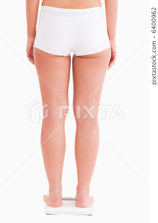 Fit woman standing on a scale 6400962