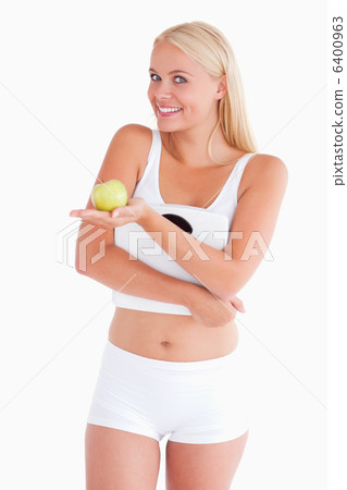 Young woman holding an apple and a scale Young woman holding an apple and a scale 6400963