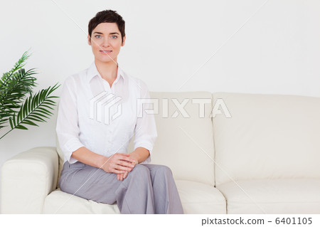 Beautiful woman sitting on a sofa 6401105