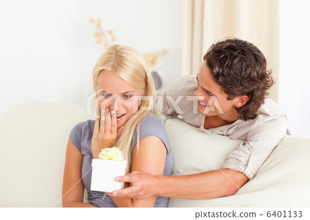 Man offering a present to his girlfriend Man offering a present to his girlfriend 6401133