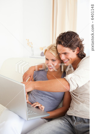 Portrait of a man showing something to his wife on a notebook 6401148